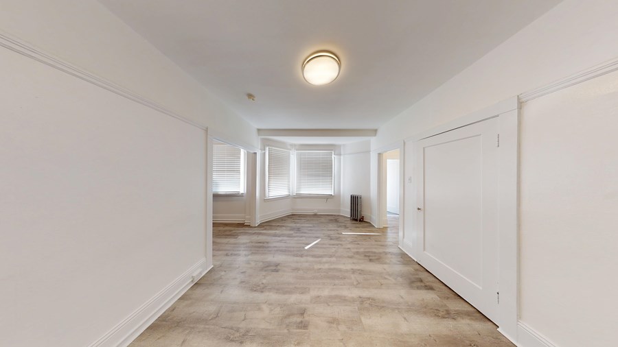 A long, empty hallway with a light on the ceiling.
